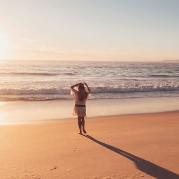 kvinde strand solnedgang på