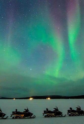 gr&oslash;nt nordlys over snescooterudflugte icehotel i svensk lapland