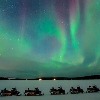 gr&oslash;nt nordlys over snescooterudflugte icehotel i svensk lapland