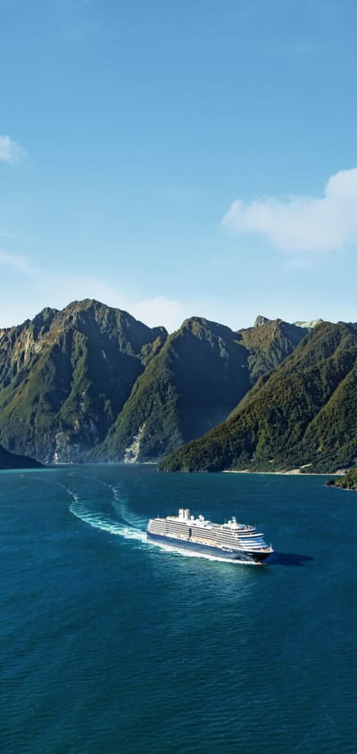 Holland America Line krydstogtskib sejler gennem Milford Sound med dramatisk bjerglandskab og vandfald