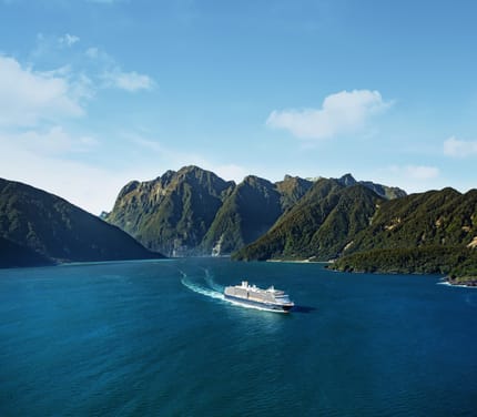 Holland America Line krydstogtskib sejler gennem Milford Sound med dramatisk bjerglandskab og vandfald