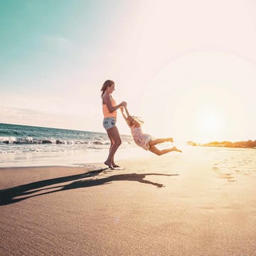 Mor og datter på strand i Spanien