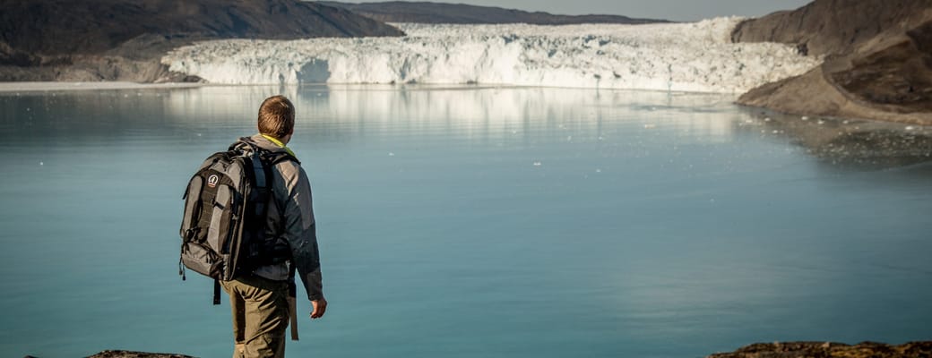 Gr&oslash;nland hiker near the eqi glacier kredit greenland scaled