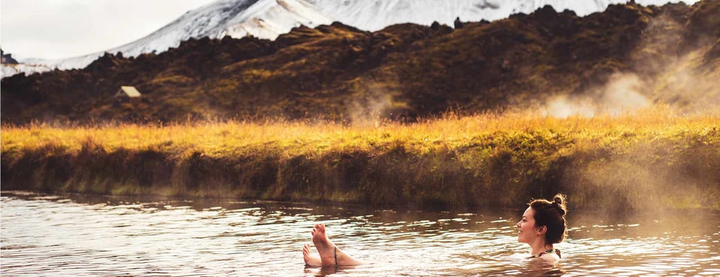 Island landmannalaugar kvinde sidder varm kilde bjeglandskab