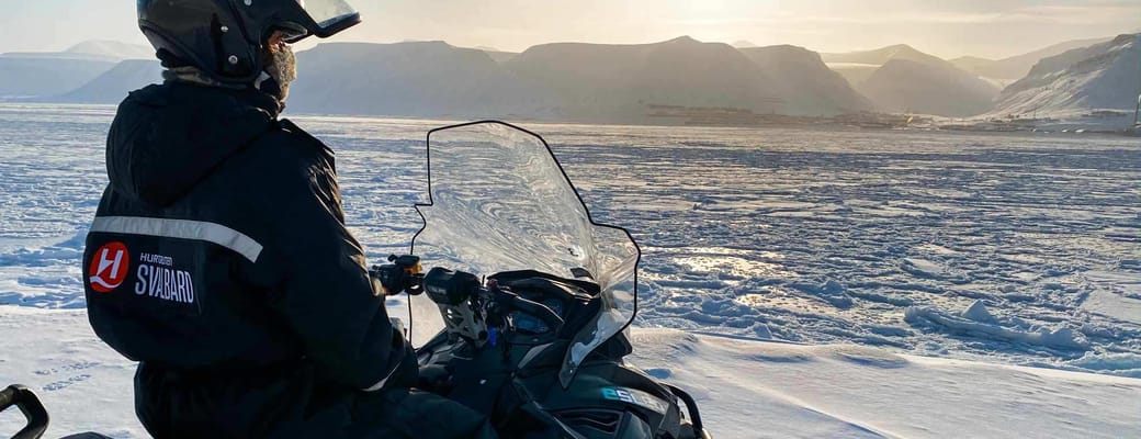 Mand siddende p&aring; snescooter
