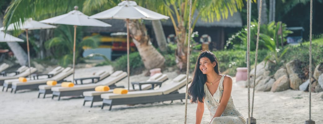 kvinde på gynge ved stranden ved kamalaya koh samui thailand