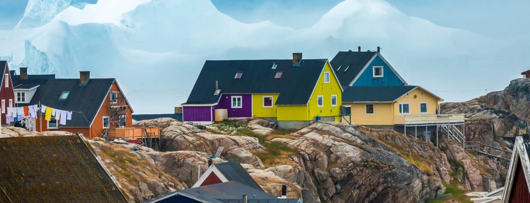 Gr&oslash;nland, Ilulissat, farvede huse og isbjerge i baggrunden