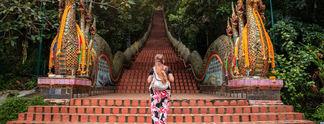 kvinde ved foden af trapperne til Doi Suthep-tempel i chiang mai nordthailand