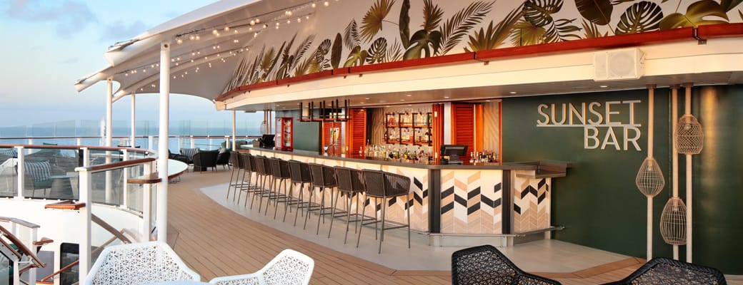 Sunset Bar på Celebrity cruise skibets øverste dæk med tropisk palmeblade-dekoration, udendørs barstemning og havudsigt