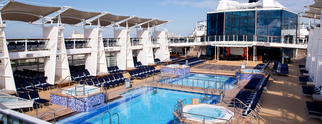 Celebrity Cruises pool-dæk med infinity pool, blå mosaikfliser, hvide markiser og solstole på luksus cruiseskib