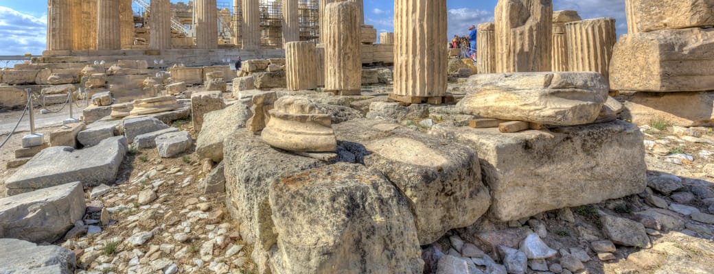 Parthenon p&aring; Akropolis i Athen, omgivet af antikke s&oslash;jler og ruiner under bl&aring; himmel