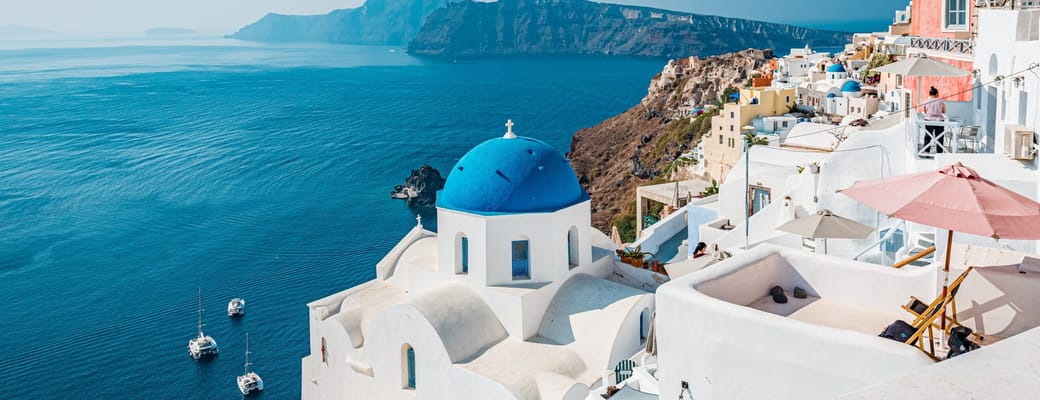 Oia p&aring; Santorini med hvide huse og bl&aring; kupler h&oslash;jt over calderaen i Det &AElig;g&aelig;iske Hav