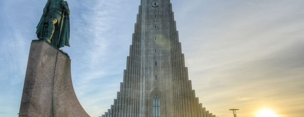 Hallgrímskirkja kirke i Reykjavik ved solnedgang med Leif Eriksson statue i forgrunden - Islands ikoniske arkitektur