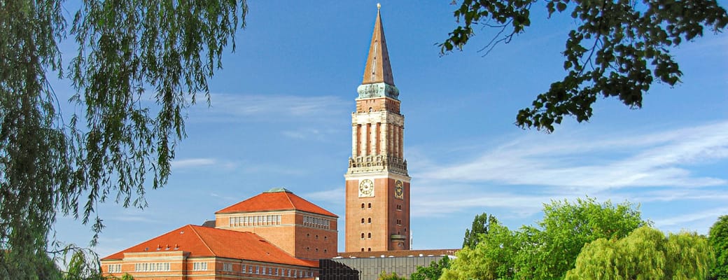 Kiels r&aring;dhust&aring;rn ved s&oslash; og gr&oslash;nne parker under bl&aring; sommerhimmel