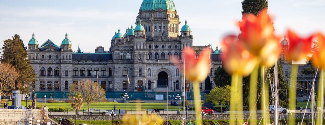 Parliament Buildings i Victoria p&aring; Vancouver Island set fra havnen med blomster i forgrunden