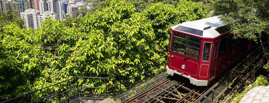 Den ber&oslash;mte r&oslash;de Peak Tram k&oslash;rer op ad Victoria Peak med Hong Kongs imponerende by og havn i baggrunden