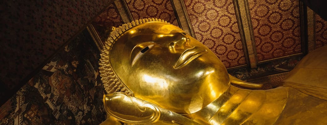 Stor gylden liggende Buddha-statue i thailandsk tempel, sandsynligvis Wat Pho i Bangkok, med udsmykket loft og turister