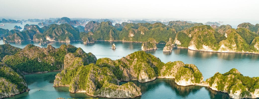 Vietnam Halong Bay luftfoto med dramatiske kalkstensformationer, gr&oslash;nne &oslash;er og turkisbl&aring;t vand, sm&aring;strande og natursk&oslash;nhed