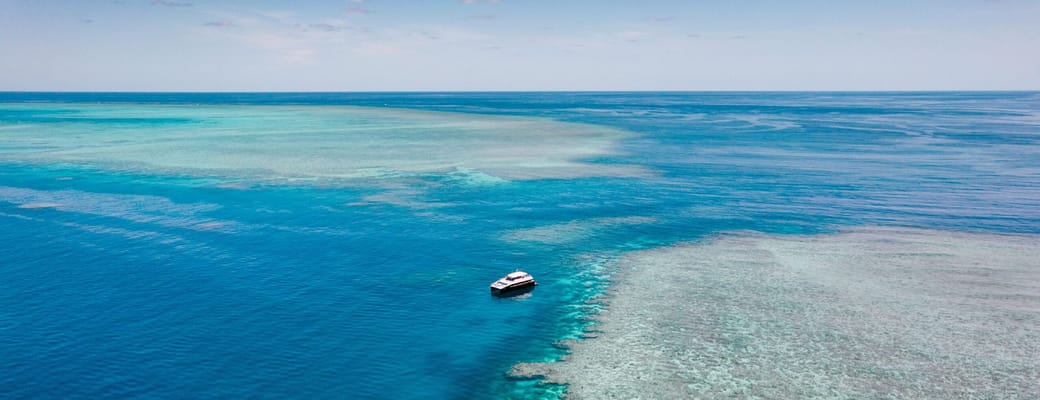 Great Barrier Reef ved Cairns med turkist koralvand og lille båd, Australien