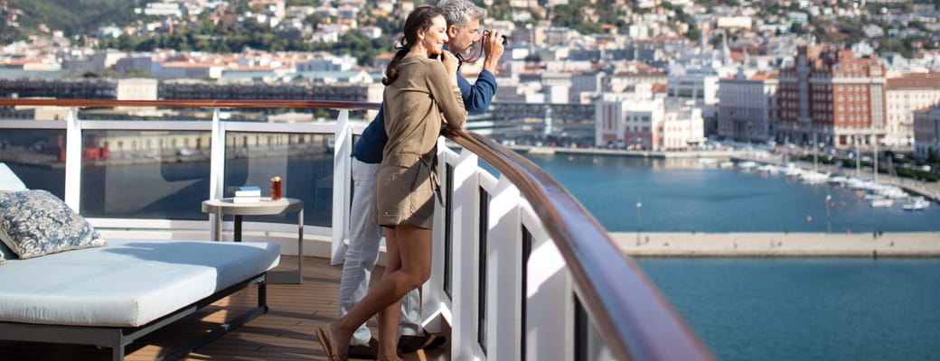 Par slapper af på privat balkon i Regent Suite på Seven Seas Explorer med havneudsigt