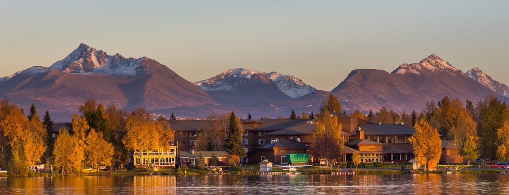 Spenard Lake i Anchorage med efter&aring;rsfarver, bjergk&aelig;de og spejling i s&oslash;en ved solnedgang