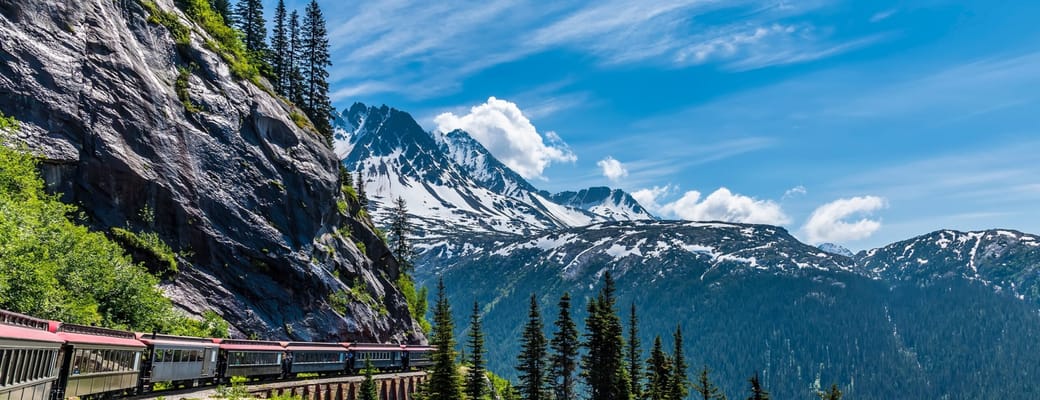 White Pass & Yukon Route toget snor sig gennem fyrreskov og snekl&aelig;dte bjerge ved Skagway