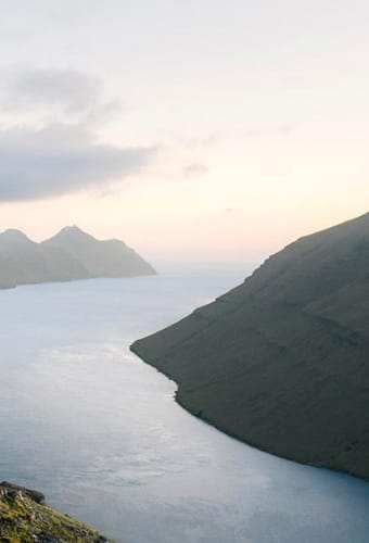 F&aelig;r&oslash;erne mand staar nyder udsigten over fjorden scaled