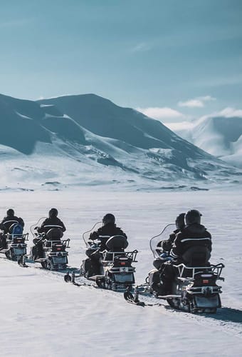 Svalbard longyearbyen gruppe snescootere raekke på kører på