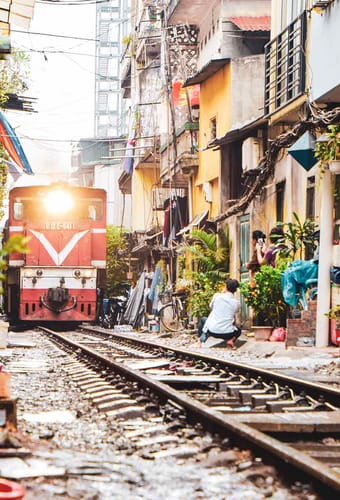 Vietnam Hanoi smal med mange tog kører gennem gade huse