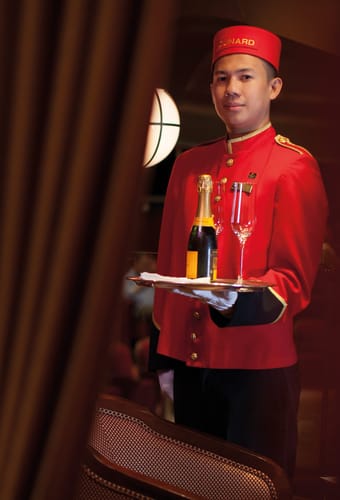 butler der står med champagne på en bakke