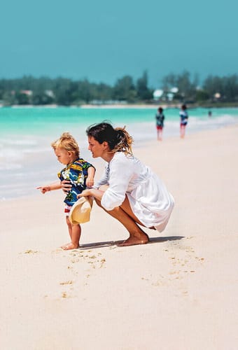 Mor og barn på stranden på Mauritius