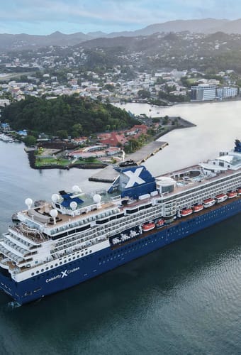 Celebrity Millennium krydstogtskib ved den tropiske &oslash; St. Lucia med gr&oslash;nne bjerge i baggrunden