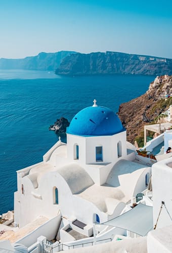Oia p&aring; Santorini med hvide huse og bl&aring; kupler h&oslash;jt over calderaen i Det &AElig;g&aelig;iske Hav