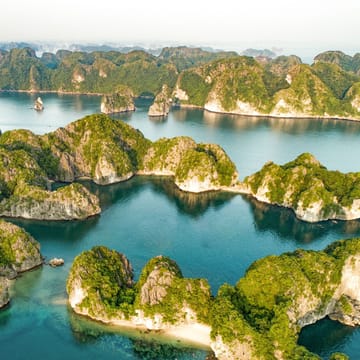 Vietnam Halong Bay luftfoto med dramatiske kalkstensformationer, gr&oslash;nne &oslash;er og turkisbl&aring;t vand, sm&aring;strande og natursk&oslash;nhed