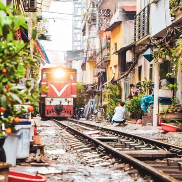 Vietnam Hanoi smal med mange tog kører gennem gade huse