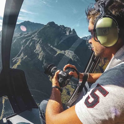 Reunion Mand Paa Helikoptertur Sidder Med Kamera