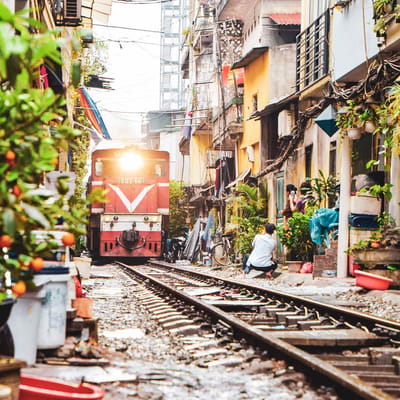 Vietnam Hanoi smal med mange tog k&oslash;rer gennem gade huse