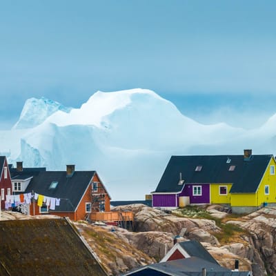 Gr&oslash;nland, Ilulissat, farvede huse og isbjerge i baggrunden