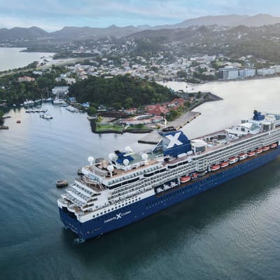 Celebrity Millennium krydstogtskib ved den tropiske &oslash; St. Lucia med gr&oslash;nne bjerge i baggrunden