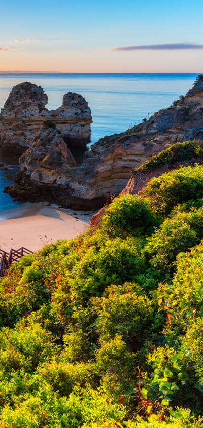 Algarve kysten på Portugal hvor der ses en strand med en trappe ned mellem klipperne