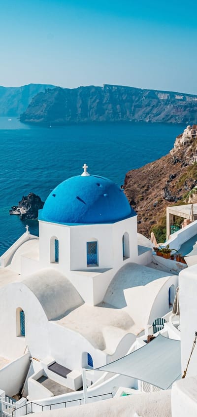 Oia p&aring; Santorini med hvide huse og bl&aring; kupler h&oslash;jt over calderaen i Det &AElig;g&aelig;iske Hav