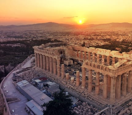 Akropolis og Parthenon i Athen set fra luften i solnedgang med storbyen bredt ud omkring