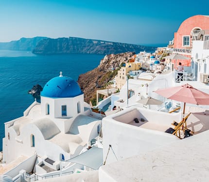 Oia på Santorini med hvide huse og blå kupler højt over calderaen i Det Ægæiske Hav