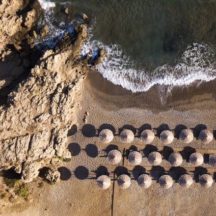 strand på kreta med parasoller og liggestole