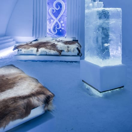 værelse på ishotellet med senge med rensdyrskind