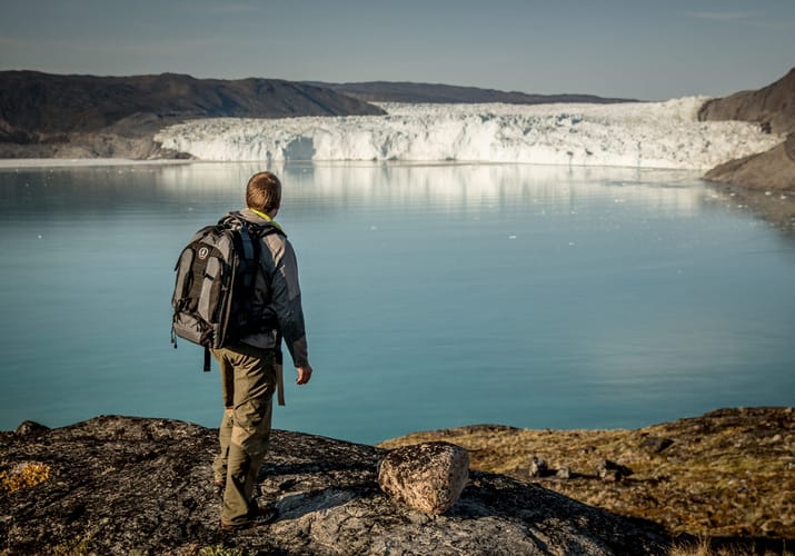 Gr&oslash;nland hiker near the eqi glacier kredit greenland scaled