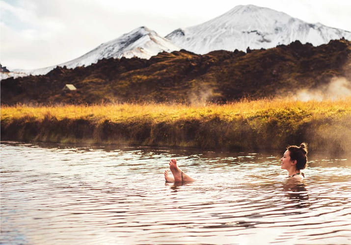 Island landmannalaugar kvinde sidder varm kilde bjeglandskab
