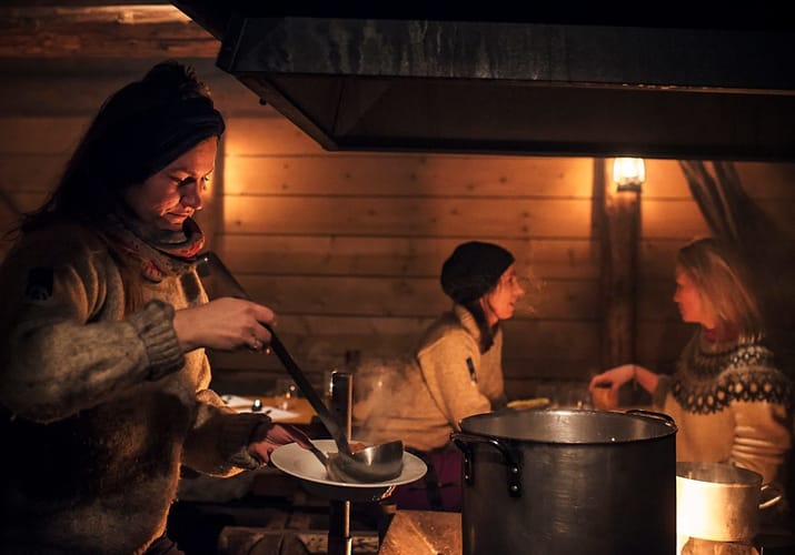 Camp Barentz: i dunkel belysning serverer kvinde suppe for 2 gæster