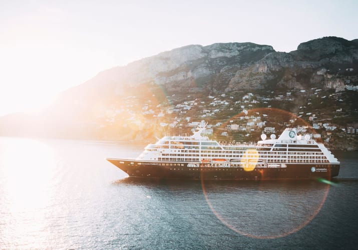 Billede af krydstogtskib fra Azamara med bjerglandskab og sol i baggrunden