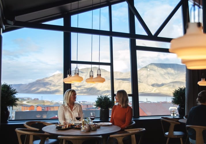 to kvinder i restauranten med udsigt til hvidklædte bjerge